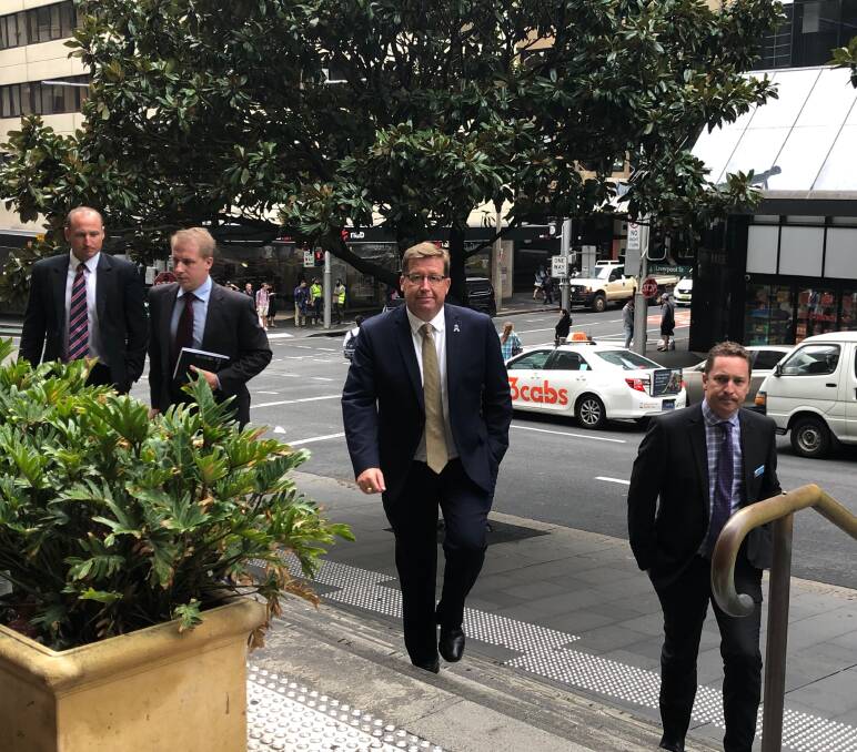 Taking the stand: Police minister and former detective Troy Grant arrives at the Downing Centre on Wednesday with detective Simon Grob, right, and detective Luke Briggs, far left.