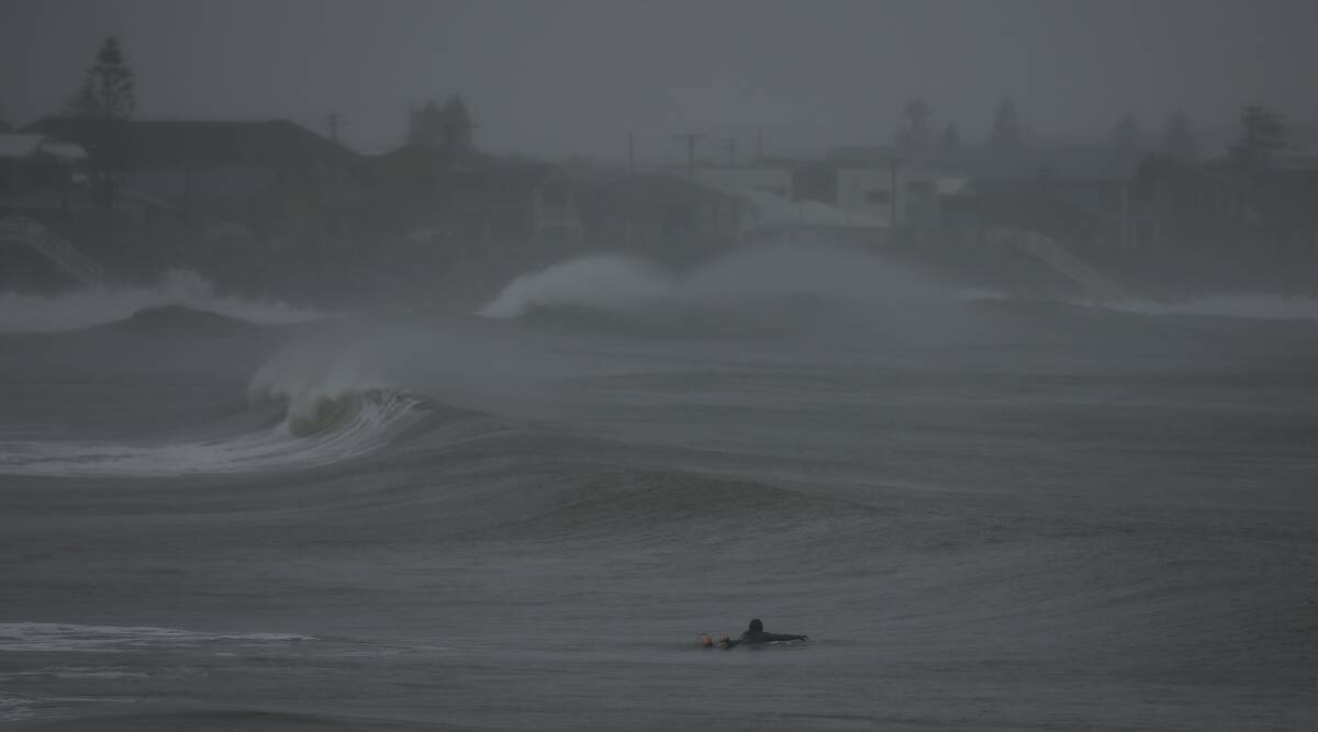 Surf's up: A lone surfer took on the waves at Stockton on Monday afternoon. Picture: Simone De Peak 
