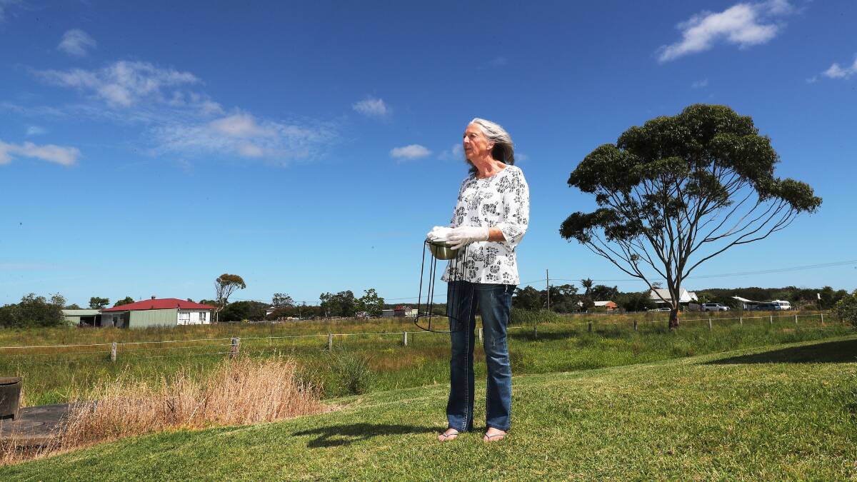 Jenny Robinson holding a PFAS monitoring device at her her Cabbage Tree Road Property. Picture by Peter Lorimer. 
