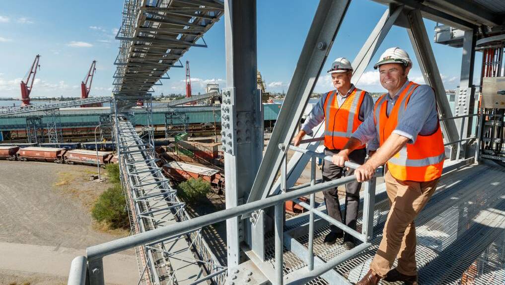 Co-CEOs of Newcastle Agri Terminal, Martin MacKay and Jock Carter, watch the loading of wheat onto a ship at their Carrington facility. Picture: Max Mason-Hubers