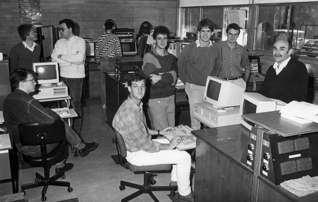 Academic staff and postgraduate students in the electrical engineering lab in 1988. Left to right: Andrew Mears, Dr Carlos de Souza, Dr Iven Mareels, Brett Ninness (seated), Steven Weller, Ross Cockerell, Peter Stepien and Professor Graham Goodwin.