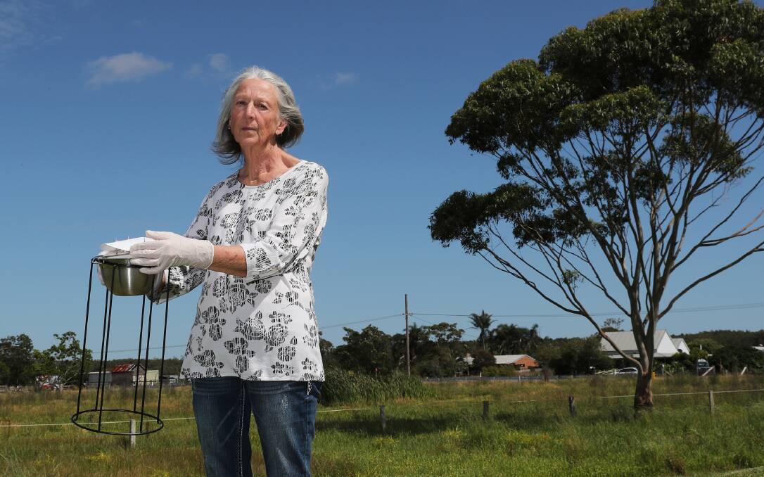 Cabbage Tree Road resident Jenny Robinson with a University of Queensland PFAS air monitor. Picture by Peter Lorimer.