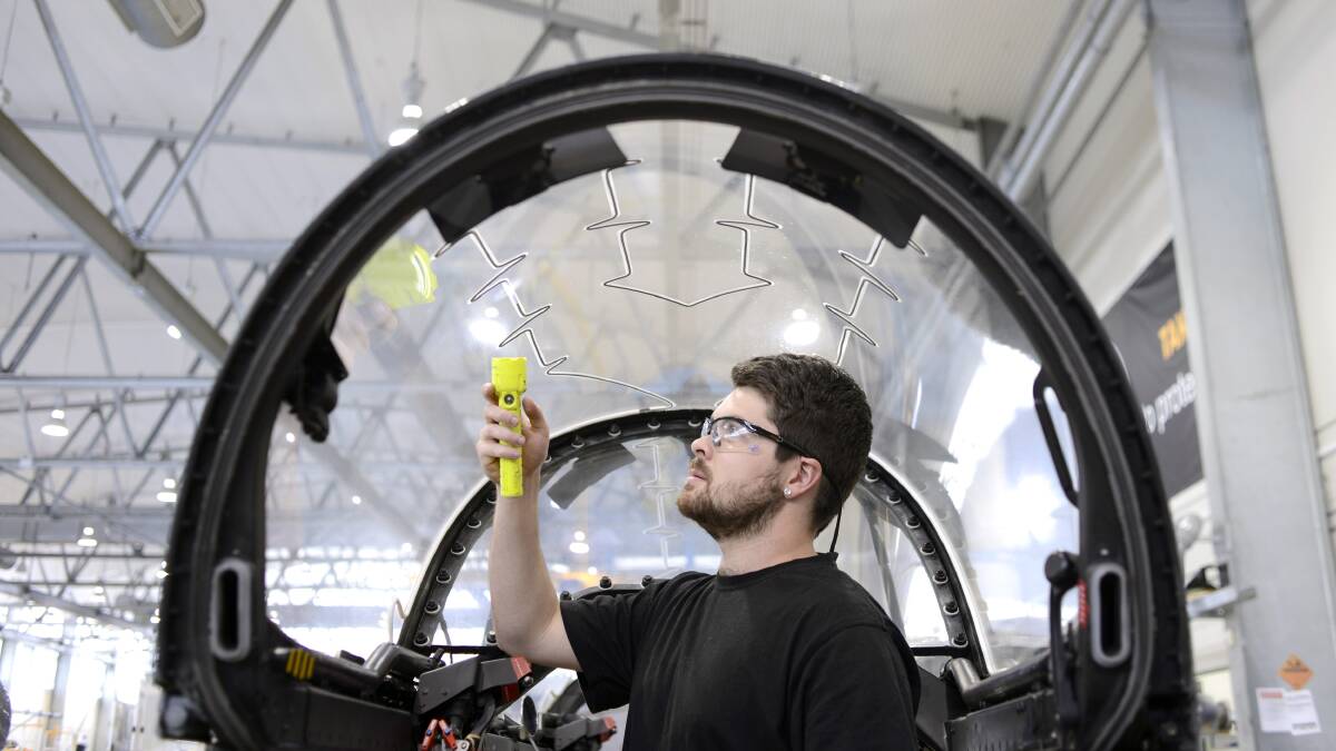 Looking to the future: A BAE Systems employee inspects a fighter jet cockpit at Williamtown. It is estimated the proposed Williamtown special activation zone could create up to 10,000 jobs. 