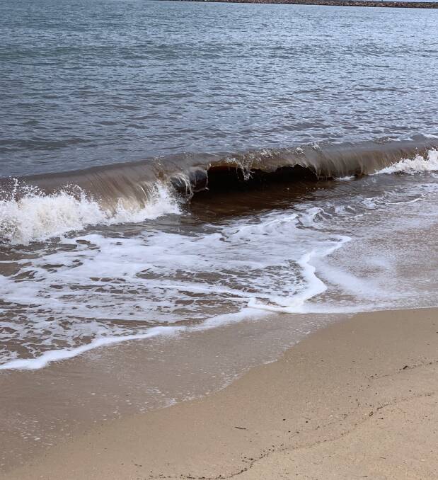 Brown tide: A wave breaks in front of the newly deposited sand. 