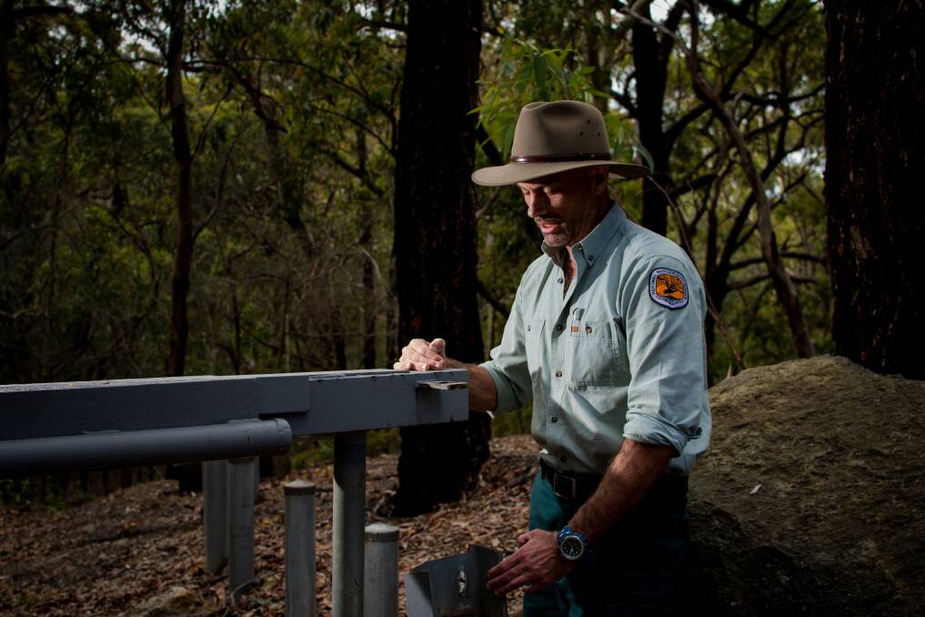 Wilful damage: Ranger Shayne O'Sullivan inspects a gate where vandals used a grinder to cut a lock to allow access. Picture: Simon McCarthy