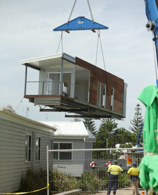 On the move: One of the 12 cabins being removed from its former home at Stockton Caravan Park. It is not know if that they will remain at their temporary location. Picture: Jonathan Carroll.