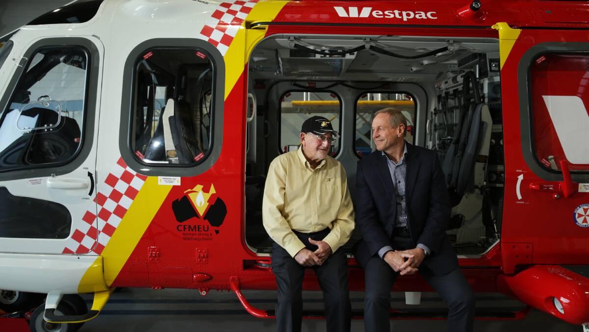 CREW CHANGE: Retiring Westpac rescue helicopter service chairman Cliff Marsh (left) with incoming chairman John Davis at the service's Broadmeadow base on Wednesday. Picture: Simone De Peak.