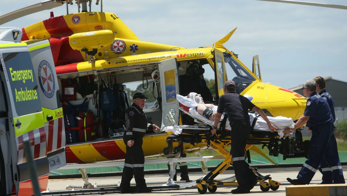 TREATMENT: The patient being loaded into the Hunter Westpac rescue helicopter to be flown to Sydney after suffering serious facial burns in explosion at Tomago. Picture: Jonathon Carroll.