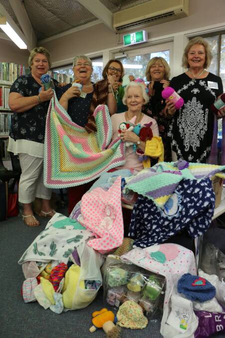 HAPPY BUNCH: Wangi Library Knitting Group founder Chris Langshaw, second from left, with members and their most recent batch of donated items. Picture: David Stewart