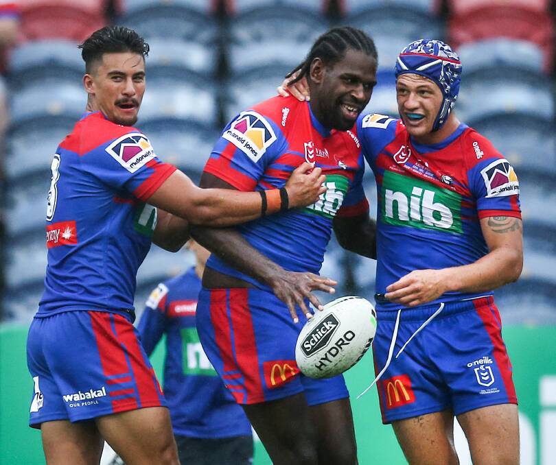 Try-time: Teammates Enari Tuala and Kalyn Ponga rush to congratulate Edrick Lee after he scored the Knights' second try against the Warriors on Saturday at McDonald Jones Stadium. Picture: Marina Neil.