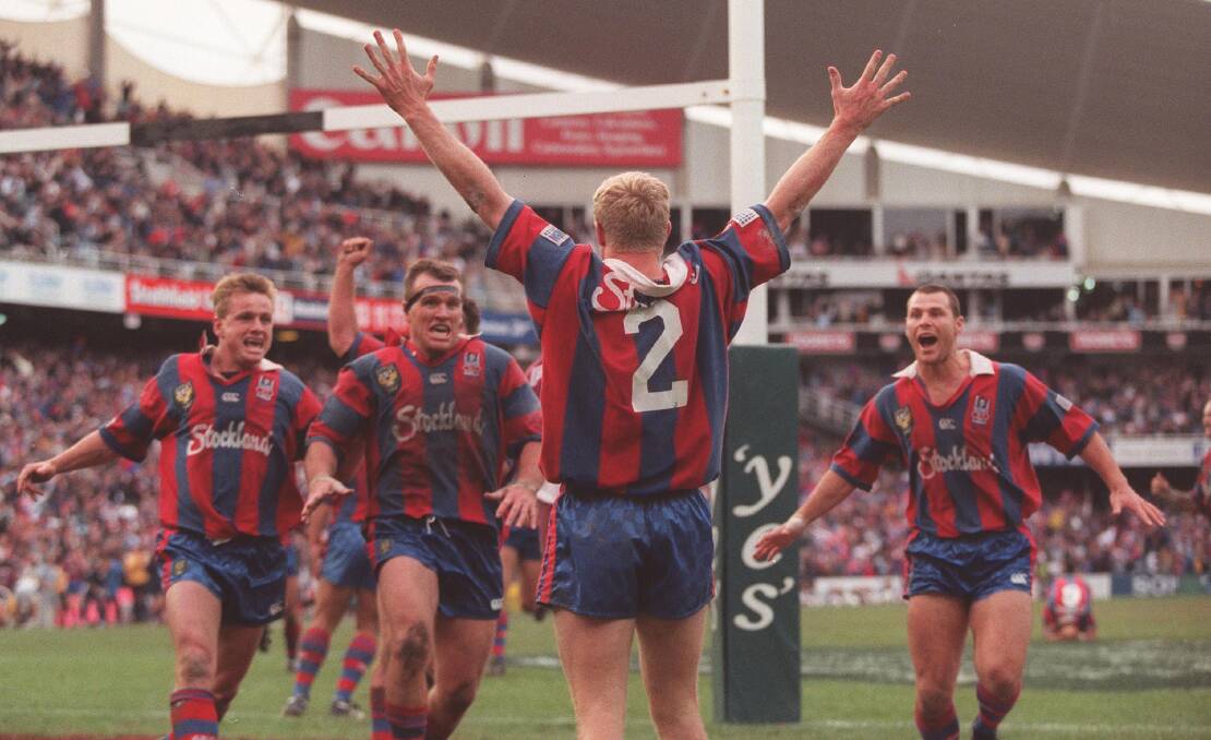 Moment in time: Elated Knights teammates rush to embrace winger Darren Albert after his match-winning try in the final seconds of his side's 1997 grandfinal triumph over Manly at the Sydney Football Stadium.