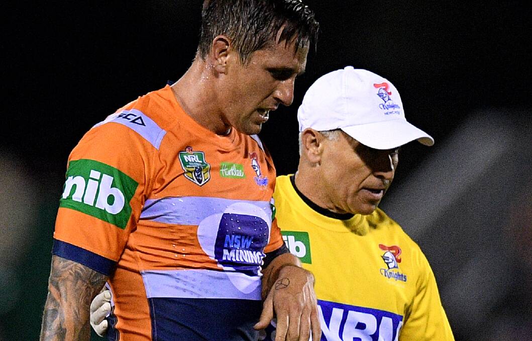 Mitchell Pearce leaves the field after rupturing his pec against the Tigers.