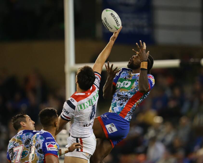 Flying high: Knights winger Edrick Lee goes up for a kick against the Sydney Roosters at McDonald Jones Stadium last season. Picture: Jonathan Carroll.