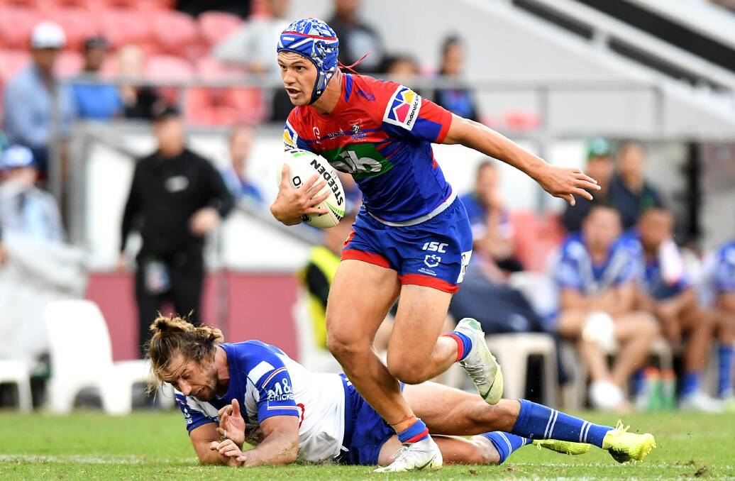 Try-time: Knights fullback Kalyn Ponga leaves Bulldogs playmaker Kieran Foran in his wake on the way to scoring a try last season. Picture: Getty Images. 