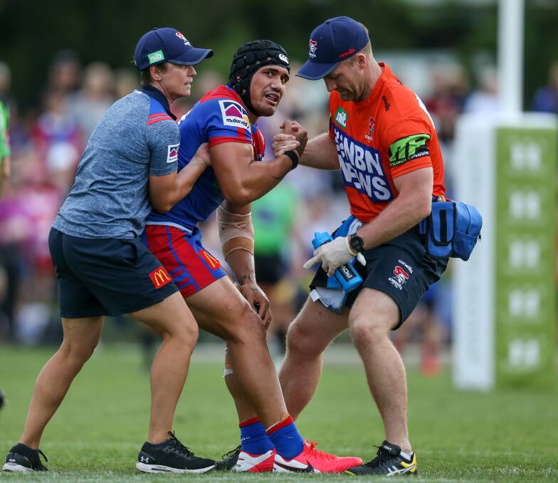 The strain: Knights star Sione Mata'utia shows his anguish after suffering a knee injury during Newcastle's trial loss to the Dragons at Maitland on Saturday. Pictures: Marina Neil.