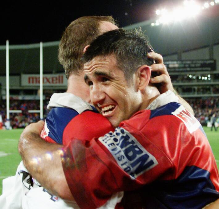 Special: Knights captain Andrew Johns shows what it means to him as he embraces teammate Adam MacDougall after their side's 2001 grand final triumph.