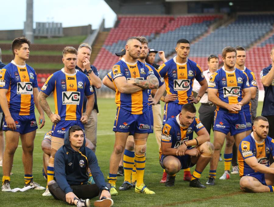 Shattered: Lakes coach Todd Edwards [third from left] alongside despondent players after their grand final defeat. Picture: Marina Neil 