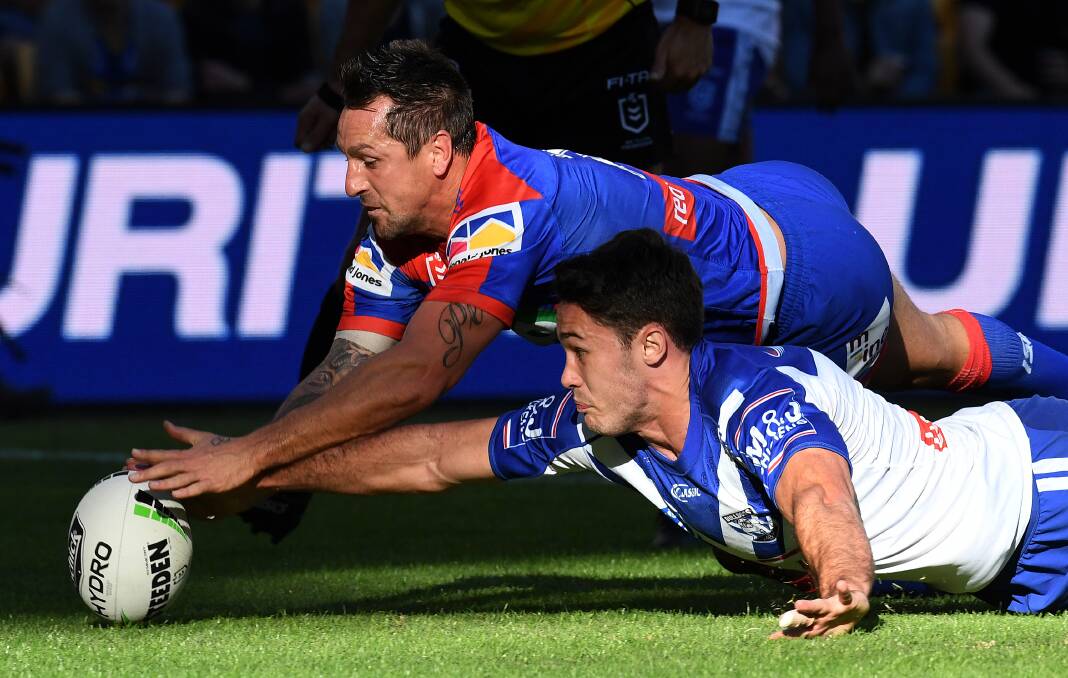 Mitchell Pearce beats Nick Meaney to the ball for a try against the Bulldogs.