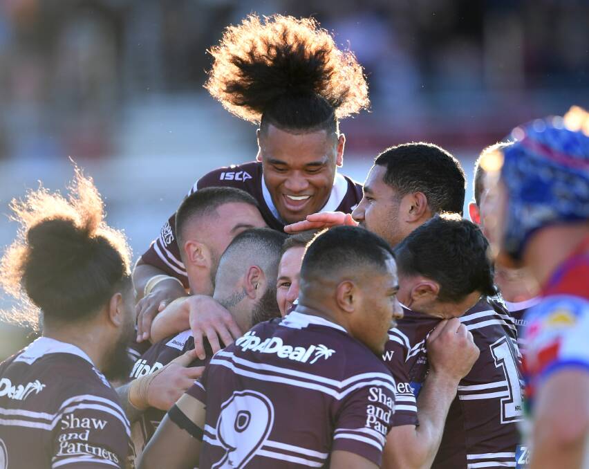 Hair-raising: Manly Sea Eagles players celebrate one of their four second half tries as they put the Knights to the sword 30-6 at Lottoland on Saturday. Picture: NRL Photos.