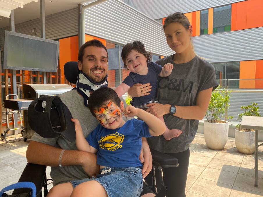 One day at a time: Chris Poulos with his family, sons Hunter and Tyson and wife Alanna, at Royal North Shore hospital. Chris will move to Royal Rehab in Ryde on Tuesday to begin his rehabilition process after a surfing accident late last year left him a quadriplegic.