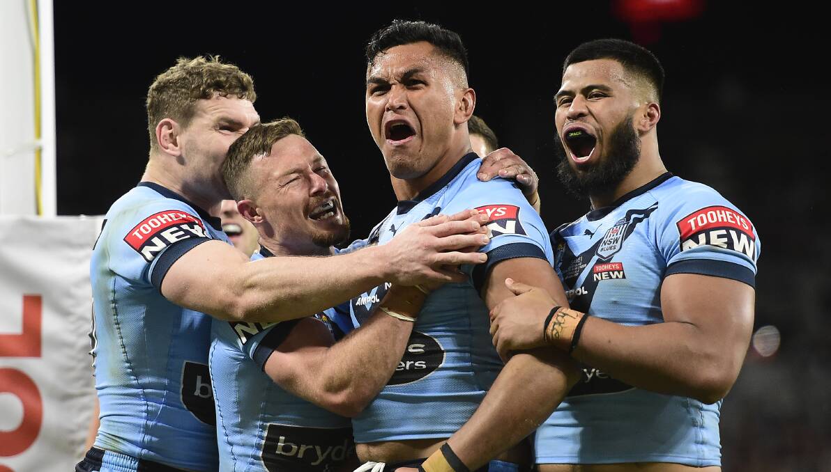 Passionate: Knights co-captain Daniel Saifiti reacts alongside teammates after storming over for a try in the NSW Blue's dominant 50-6 thrashing of Queensland in Origin I on Wednesday night in Townsville.