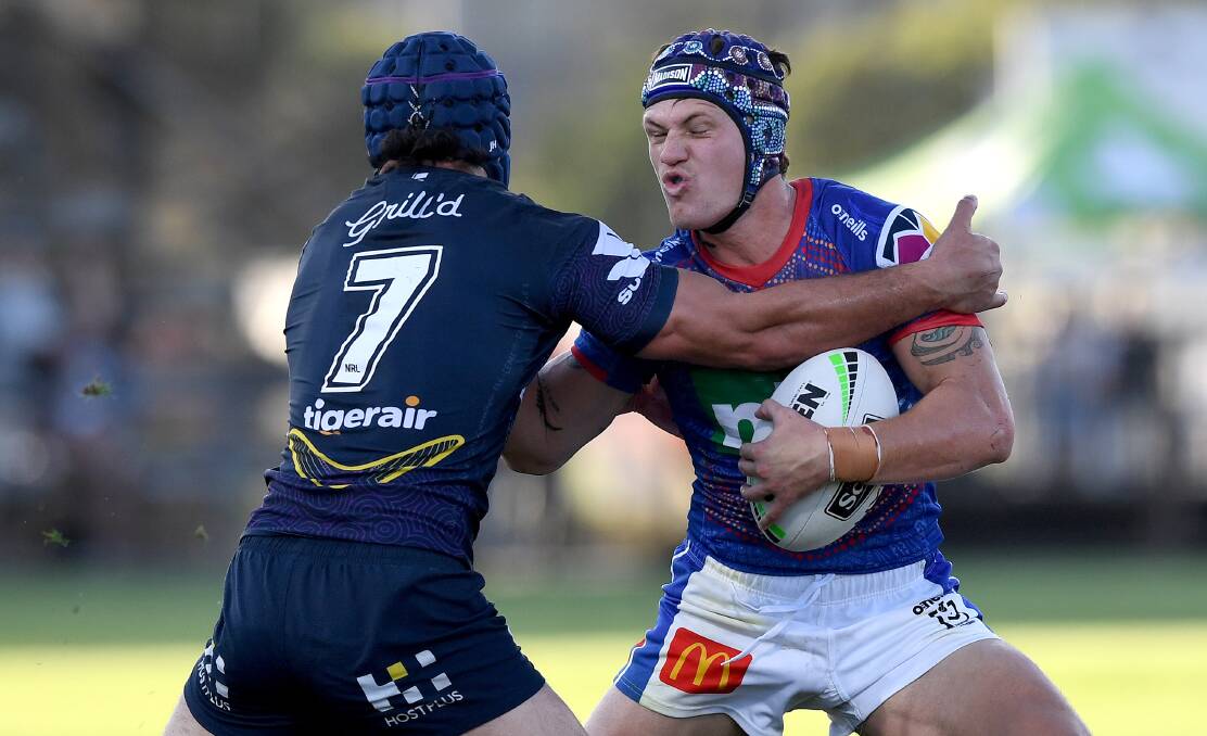 Wrapped up: Knights fullback Kalyn Ponga is smothered in a tackle by Storm halfback Jahrome Hughes during Newcastle's 26-16 loss on the Sunshine Coast. Picture: Getty Images.