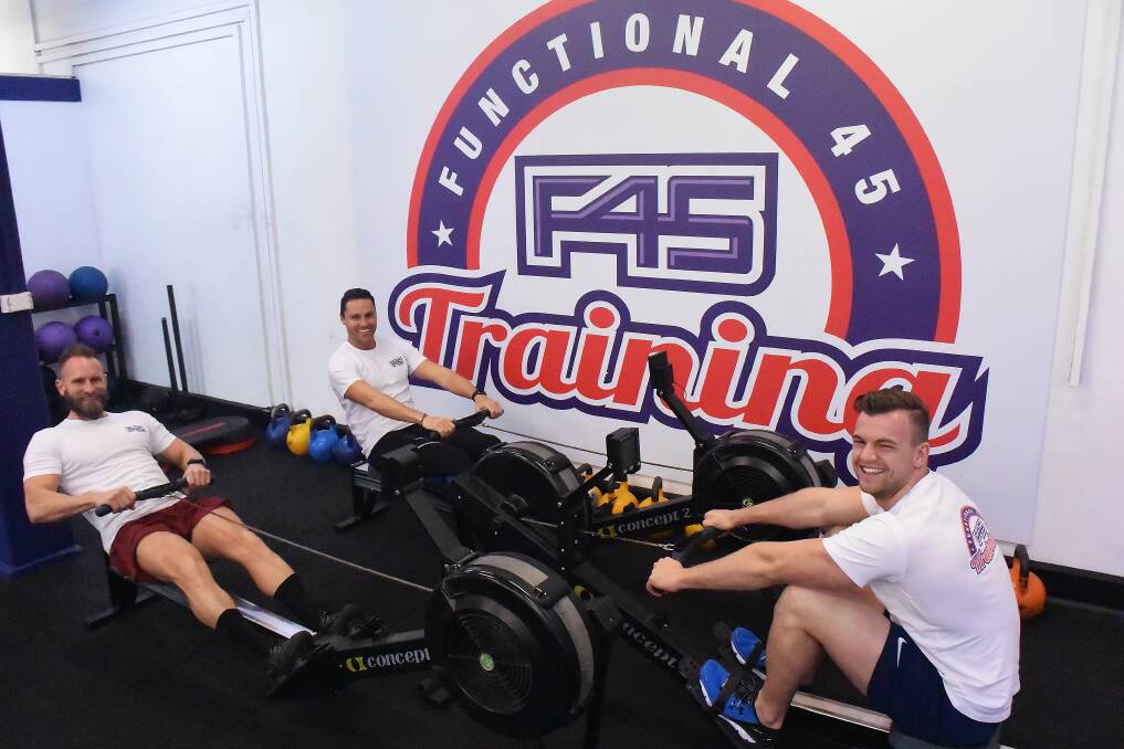 Show of strength: F45 Newcastle and Warners Bay owners Jamie Shoemark, left, and Jordan Nisbet, right, with manager Mike Wilkins, centre. 