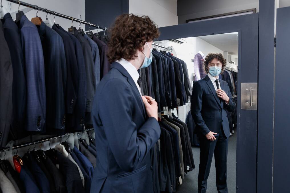 Formally excited: "I am just grateful that it's still on," St Philips Christian College Newcastle Rory Garland said, trying on a suit at Rundle Tailoring, of his school's December 1 formal. Picture: Max Mason-Hubers