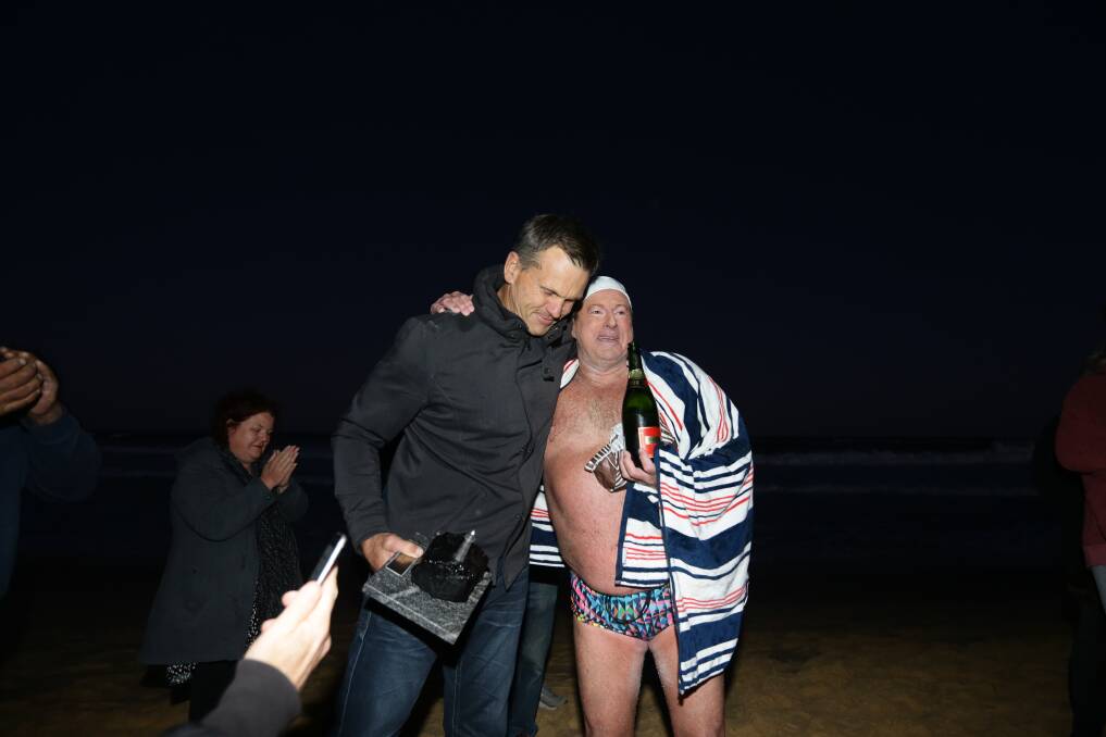 Welcoming party: Knights legend Paul Harrogan was among the family and friends who welcomed Craig Clarke to shore after his "Coals to Nobbys" swim in August, 2020. Picture: Jonathan Carroll 