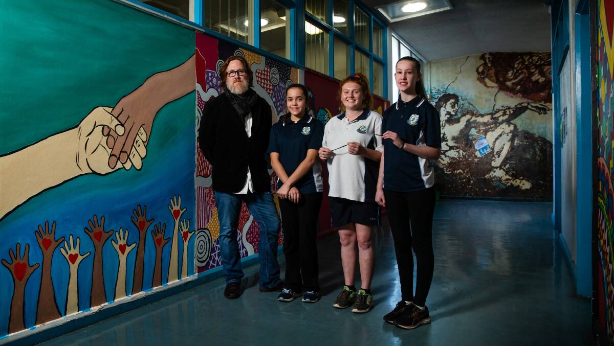 Bright: Teacher Andrew Smith, Shantel Brooks, Alyssa Charter-Smith and Ella Brown. Year eight student Shantel said the new mural "makes you feel part of something, like you're not left out, you feel proud". Picture: Marina Neil