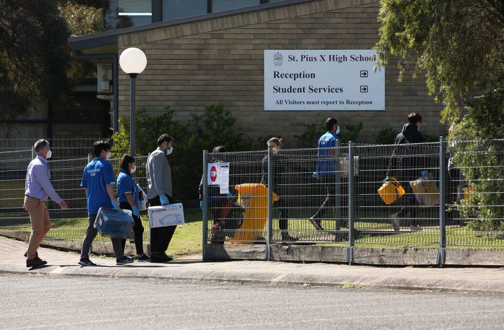 Priority: Cleaners start work at St Pius X High on Thursday. Picture: Simone De Peak
