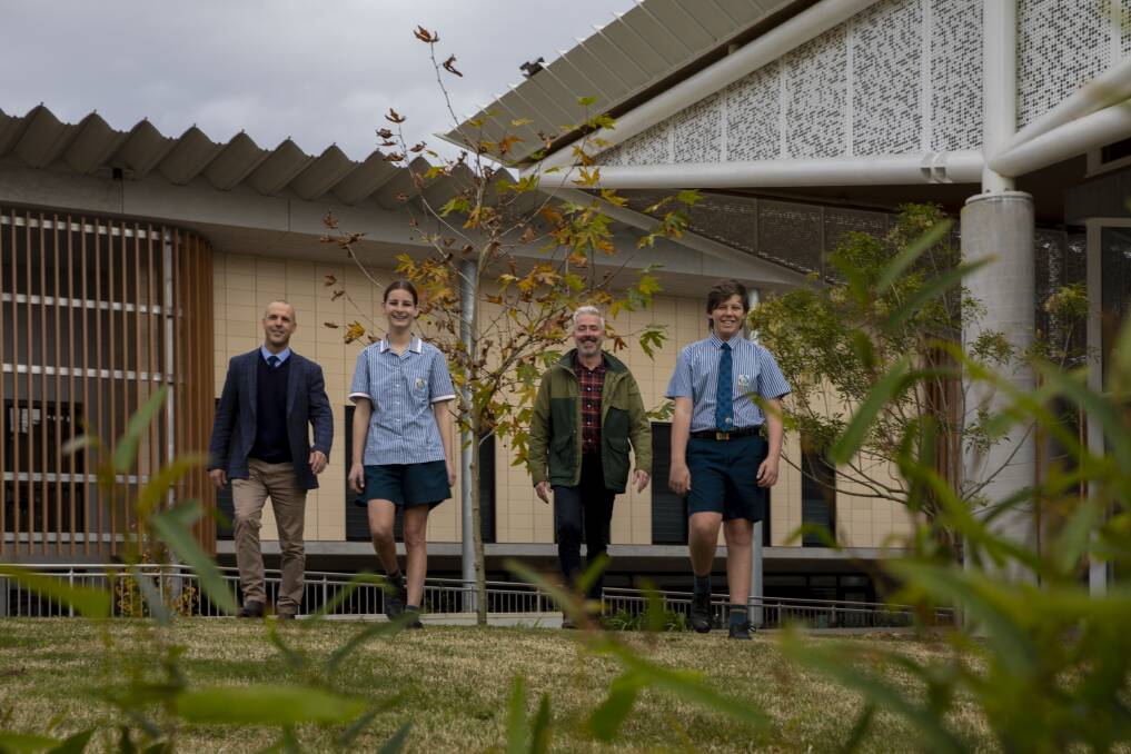 Environmental advocates: Scott Donohoe, year eight students Isabelle Lilley and Curtis Humble and Sustainability Manager for the Diocese of Maitland-Newcastle, Daan Schiebaan. The school's energy efficient features complement its natural bushland setting.
