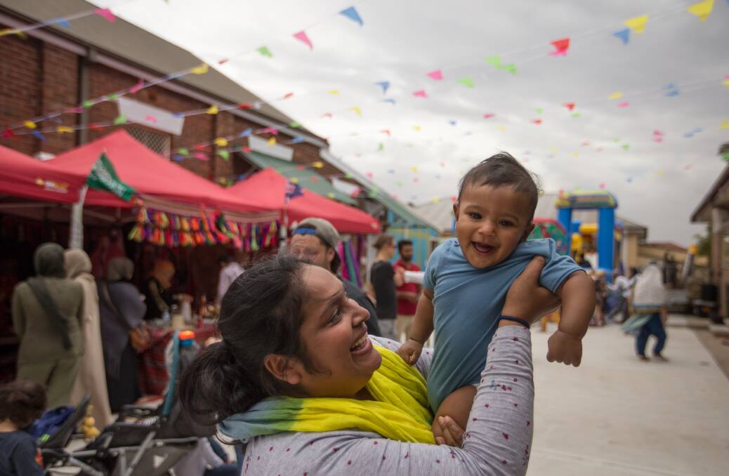 Happy: Shohana Pervin from Elermore Vale with baby Nafi. Face painting and henna tattoos were moved inside the hall, where food was being served. Picture: Marina Neil