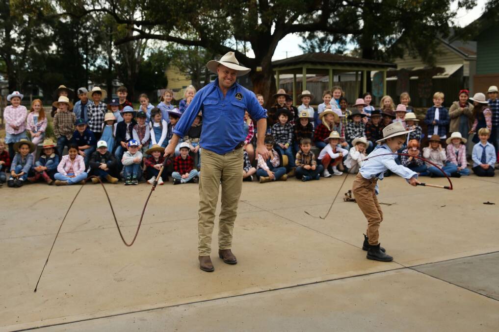 Family effort: Steve and Benny Binnie showed students how to crack a whip, before hosting a barbecue. Picture: Jonathan Carroll