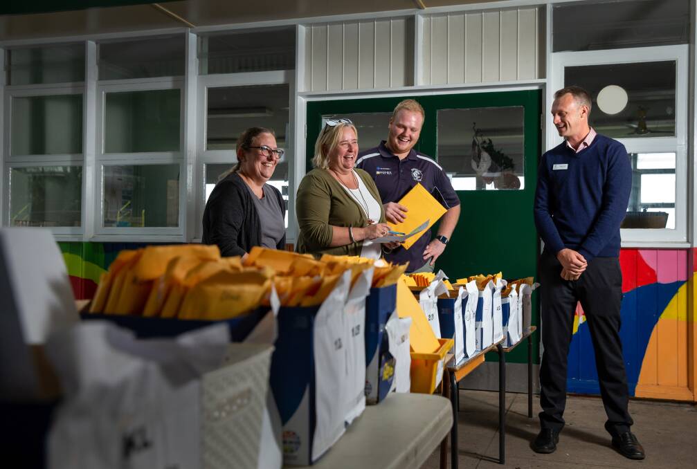 Team effort: Susan Taranawiwat, Megan Dowler, Liam Janczuk and Nathan Forbes assemble home learning packs for families to collect. Mr Forbes thanked families for their support of and engagement with the school and kind words about teachers' efforts. Pictures: Marina Neil