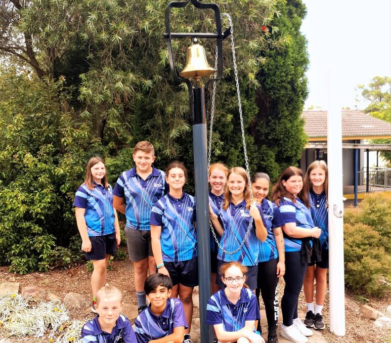 Terrific: Teralba Public captain Jasmine, holding the chain, and year six peers with the new and engraved bell. They rang it on Wednesday, the last day of school.