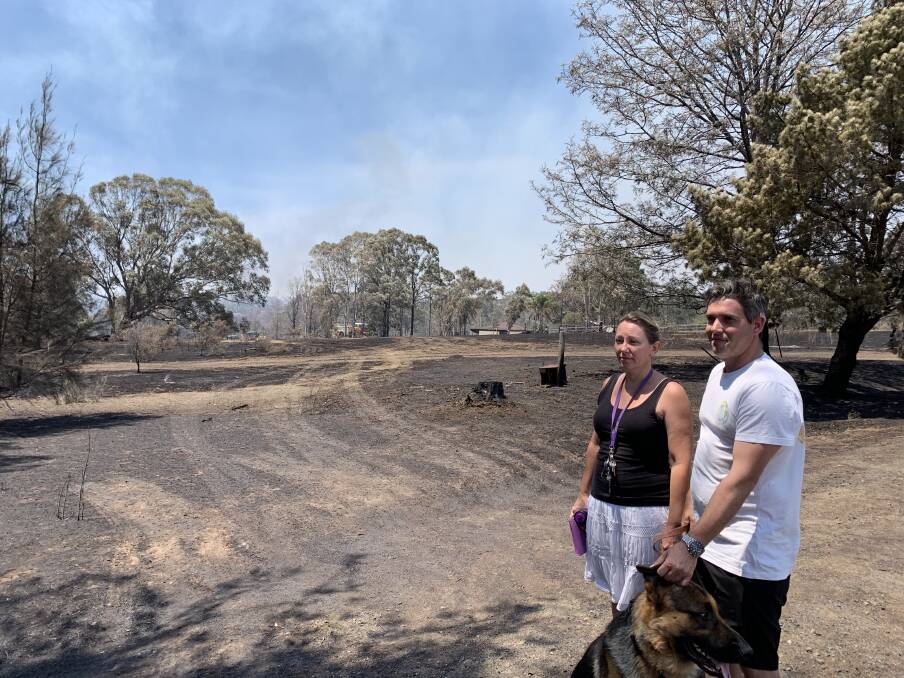 Concerned: Leeanne and Jamie Whybrow with dog Quill as crews fight the blaze. Picture: Helen Gregory