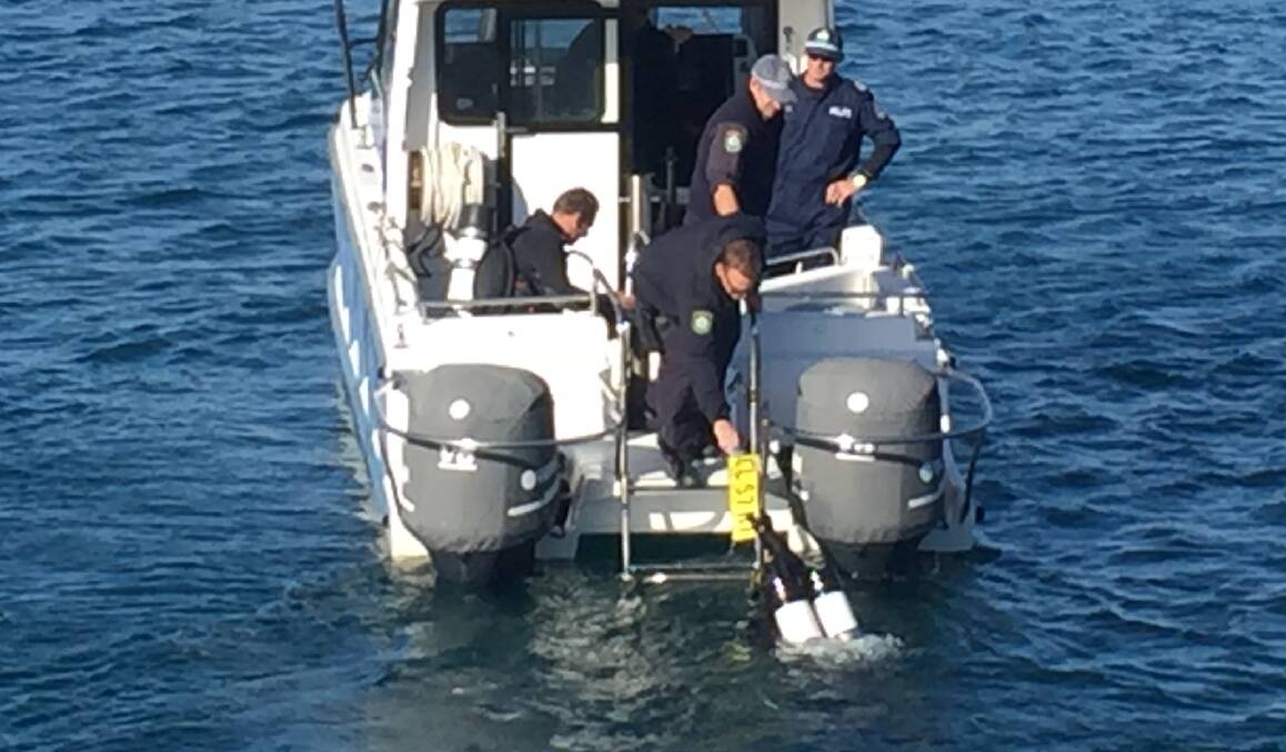 Police divers retrieve the car's number plate on Thursday. Picture: Brodie Owen