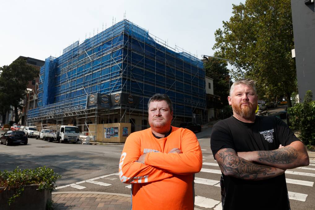 NOT GOOD ENOUGH: Construction, Forestry, Mining and Energy Union (CFMEU) organisers Mark Cross, left, and Brendan Holl outside an apartment development that is being built by MARS Building on King St, Newcastle.