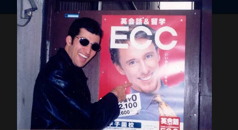 City of Newcastle chief executive Jeremy Bath standing in front of a poster of Scott Neylon advertising an English school in Kyoto, Japan. 