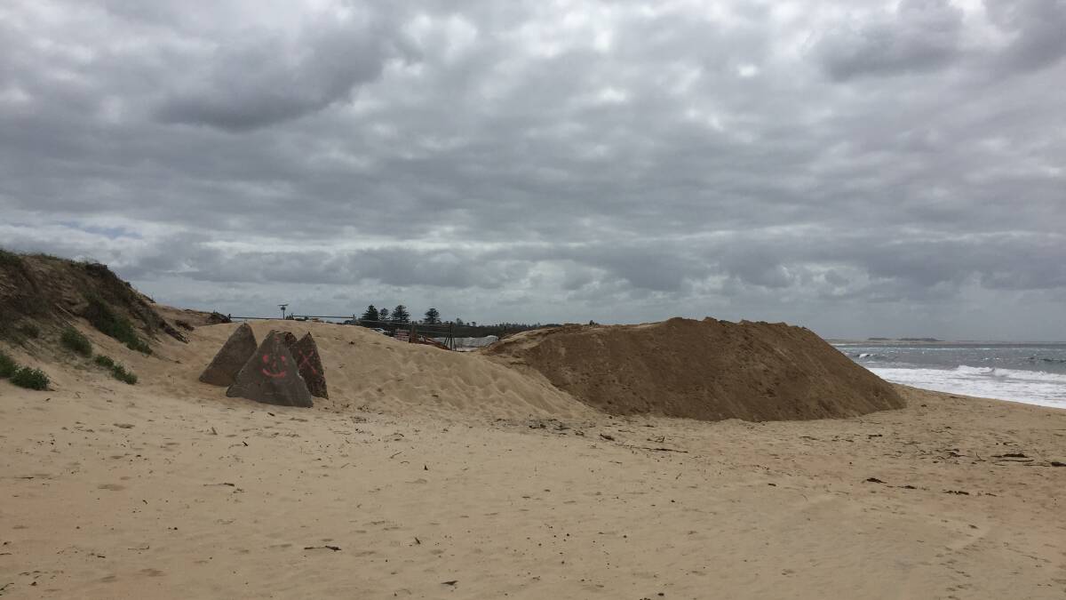 SEA WALL: A mountain of sand is being used to protect workers from the tide during the construction works at the former Newcastle City Council rubbish tip site.