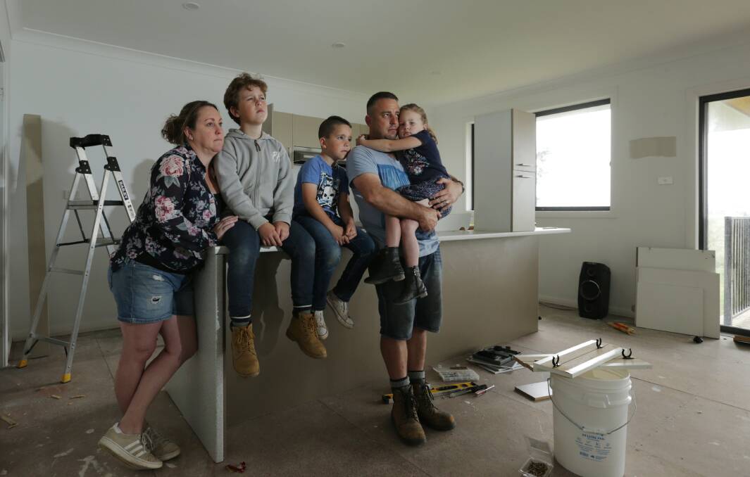 FINANCIALLY BROKEN: Phillip Kapeller and Rachael Cesnik with their children Loui, 10, Zeke, 8, and Violet, 5. The family was left with no option but to take crippling legal action after a builder left their Gillieston Heights dream home unfinished and full of defects. Pictures: Simone De Peak