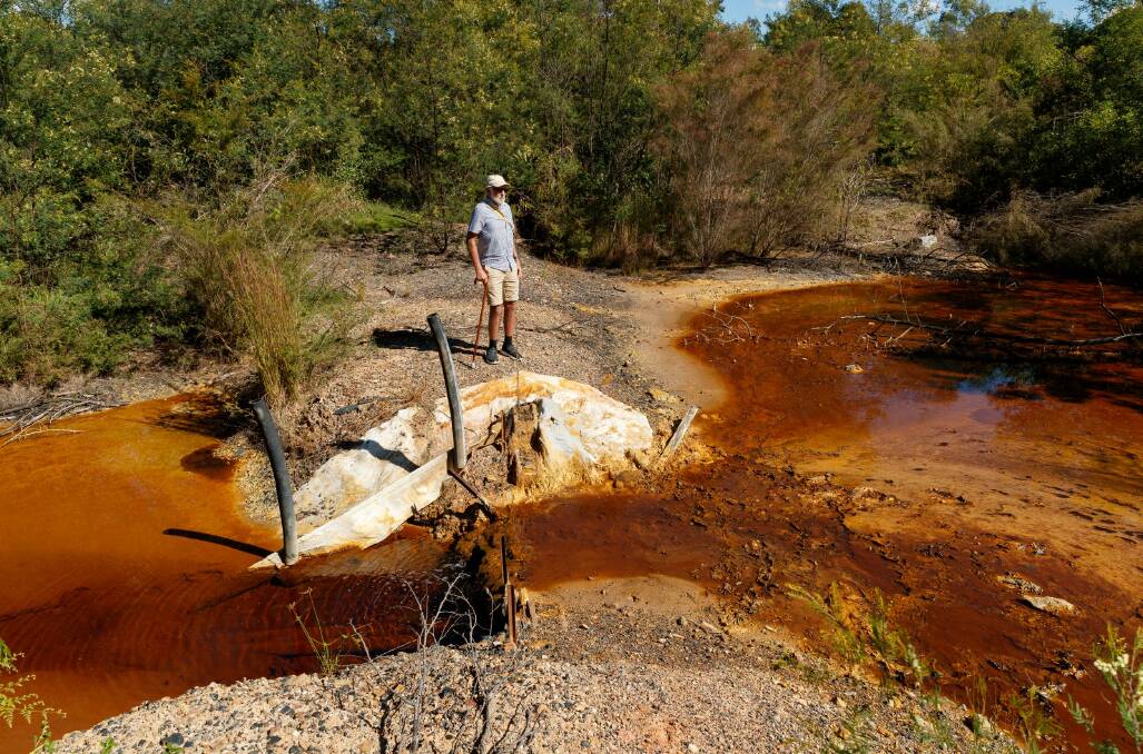 RED AND DEAD: Kurri Kurri Landcare member Col Maybury has been fighting to have acid-poisoned Lower Hunter coalmine sites cleaned up for more than 30 years. Picture: Max Mason-Hubers