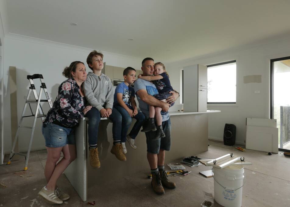 FINANCIALLY BROKEN: Phillip Kapeller and Rachael Cesnik with their children Loui, 10, Zeke, 8, and Violet, 5. The family was left with no option but to take crippling legal action after a builder left their Gillieston Heights dream home unfinished and full of defects. Pictures: Simone De Peak
