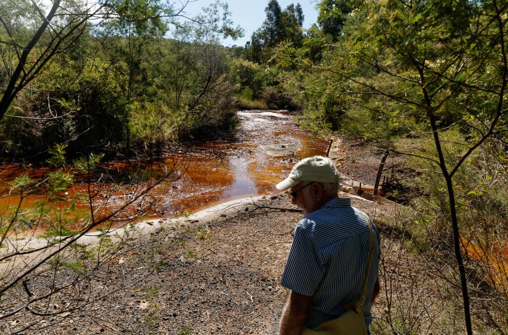 RED AND DEAD: Kurri Kurri Landcare member Col Maybury, pictured at Neath, has been fighting to have acid-poisoned Lower Hunter coalmine sites cleaned up for more than 30 years. Picture: Max Mason-Hubers