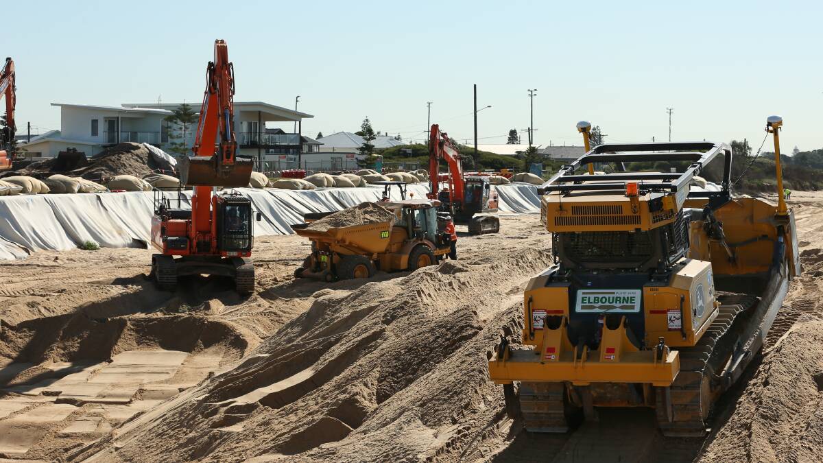 DRY: A temporary sand wall is being built between the sea and work area. Picture: Simone De Peak