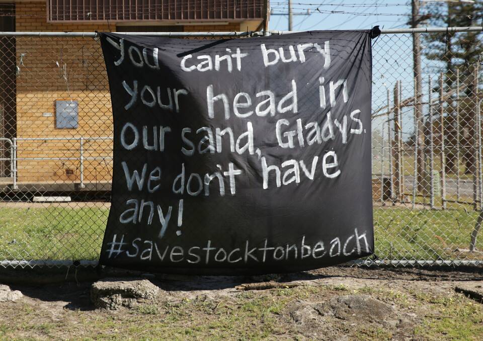 FED UP: Stockton residents display their anger at what they believe is state government inaction on the erosion crisis that has forced the closure of the beach and suburb's childcare centre. Picture: Simone De Peak