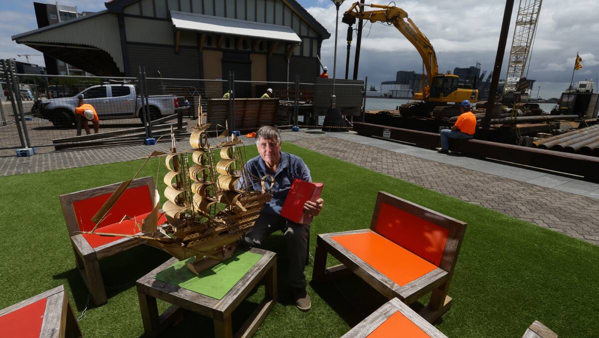 Bob Cook with a model ship and a Lloyds Shipping Register that were salvaged from a skip bin in 2018. Picture: Jonathan Carroll.