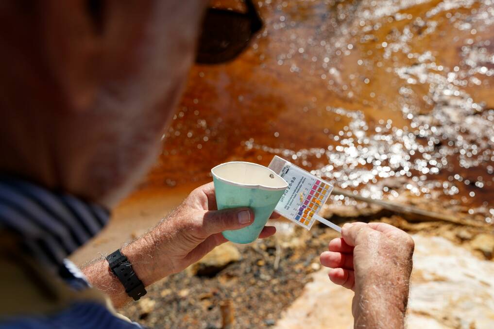 TOXIC: Kurri Kurri Landcare's Col Maybury testing the pH, the measure of acidity, in a creek near the coal spoil dumps at Neath. Picture: Max Mason-Hubers