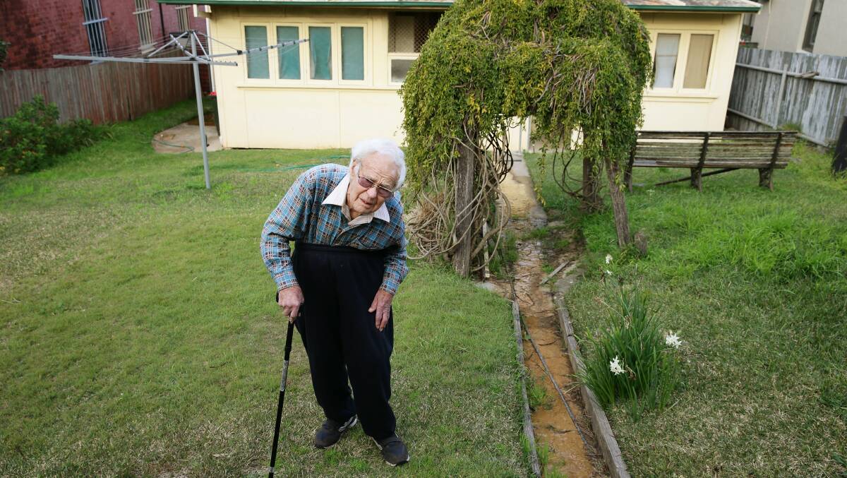 BATTLE: The late Allen Watson in 2013 at his Waratah home that was inundated for more than thirty years by water from old mine workings behind his back fence.